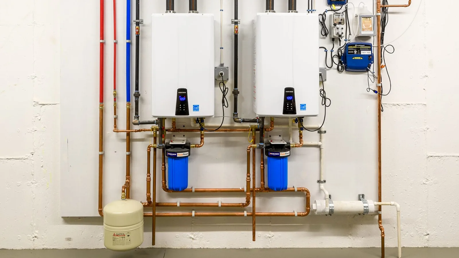 Two wall-mounted tankless water heaters piped in copper
